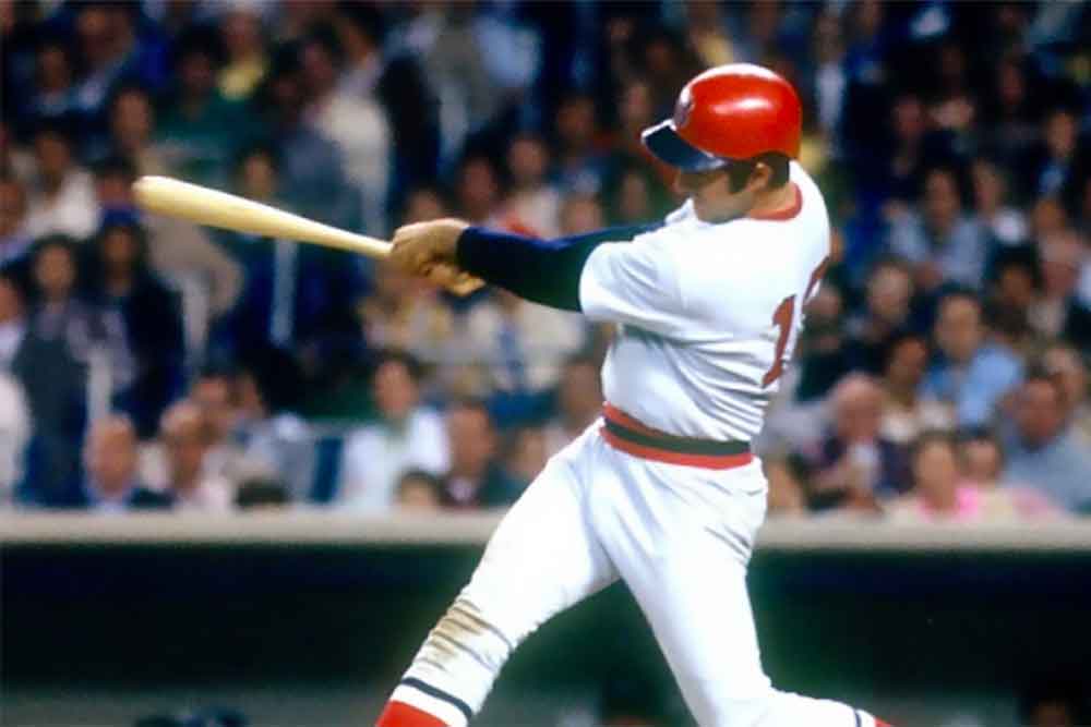 Fred Lynn, baseball legend and 1975 MVP, is shown swinging a bat in his Boston Red Sox uniform during a game, capturing a classic MLB moment for fans on the Fred Lynn official website.| Fredlynn.com | Official Home of Fred Lynn